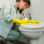 Young Woman Cleaning the Toilet