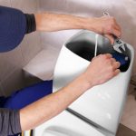 Plumber working on toilet